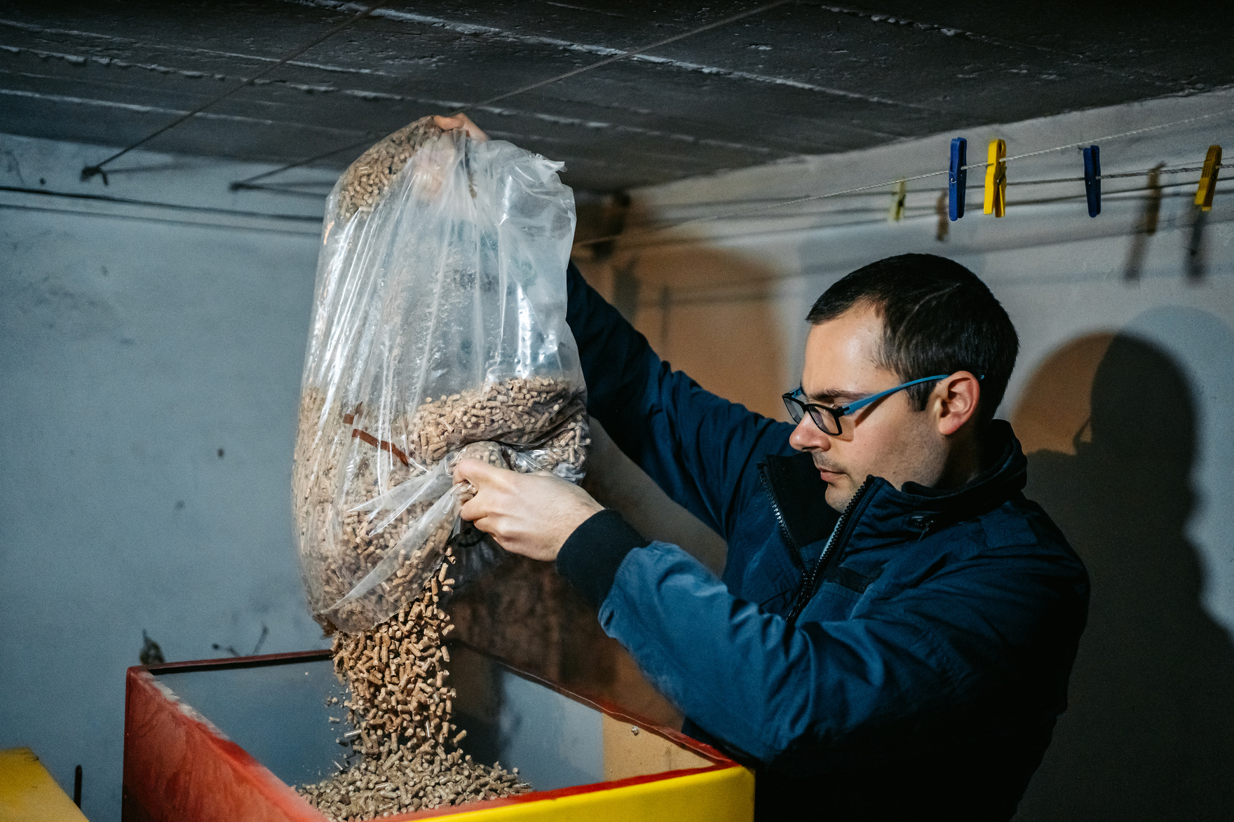 Man pouring pellets in pellets boiler